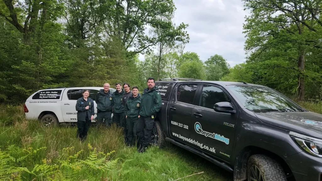 Line-up of NHS ambulances and Beyond Driving Hilux vehicles in wooded training site