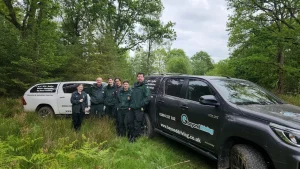 Line-up of NHS ambulances and Beyond Driving Hilux vehicles in wooded training site