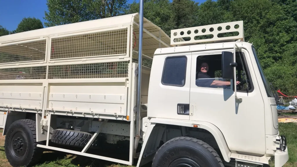 Side view of a safari truck with a smiling female driver at the wheel