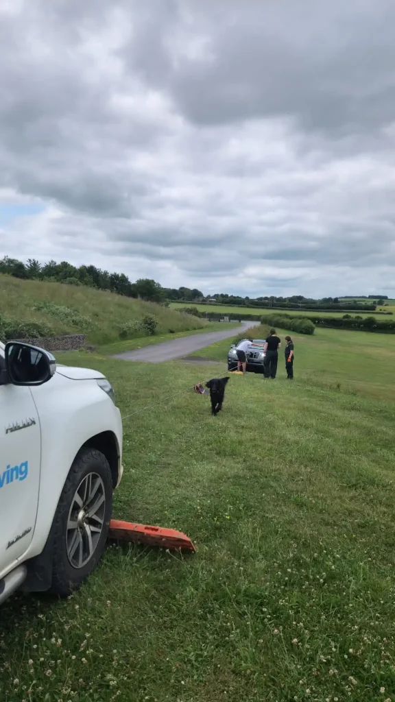 Beyond Driving instructors and NHS HART team using traction boards and winch cable on a hillside training scenario