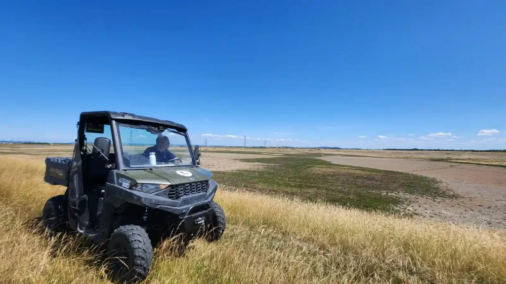 Polaris UTV parked in long grass during Lantra training for WWT at Steart Marshes.
