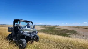 Polaris UTV parked in long grass during Lantra training for WWT at Steart Marshes.