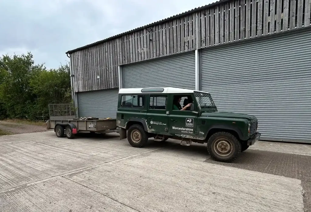 Land Rover Defender towing flatbed trailer outside workshop during Lantra Trailer Handling course in Worcestershire