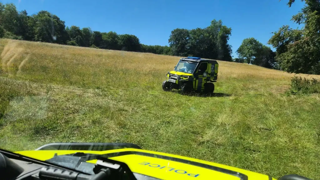 Polaris Ranger UTV on grassland as seen from inside another police vehicle during rural operator training