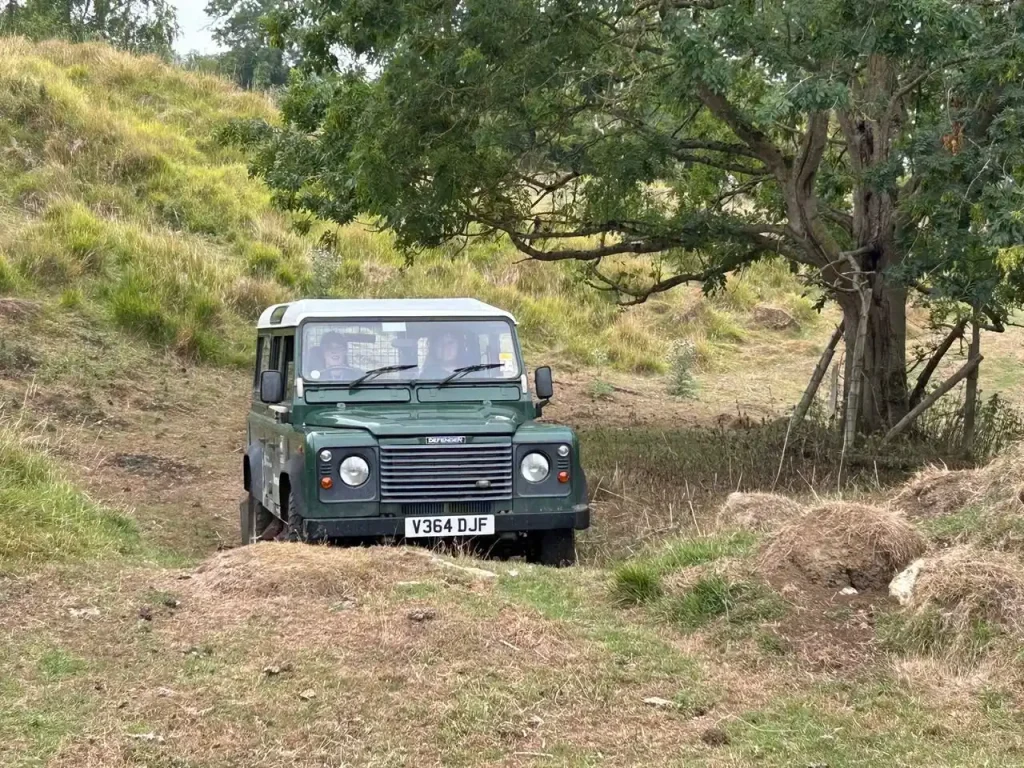 Land Rover Defender tackling uneven off-road terrain during Lantra 4x4 operator training with Beyond Driving