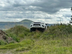 Toyota Hilux 4x4 ascending a grassy incline during off-road driver training in Fife with Beyond Driving