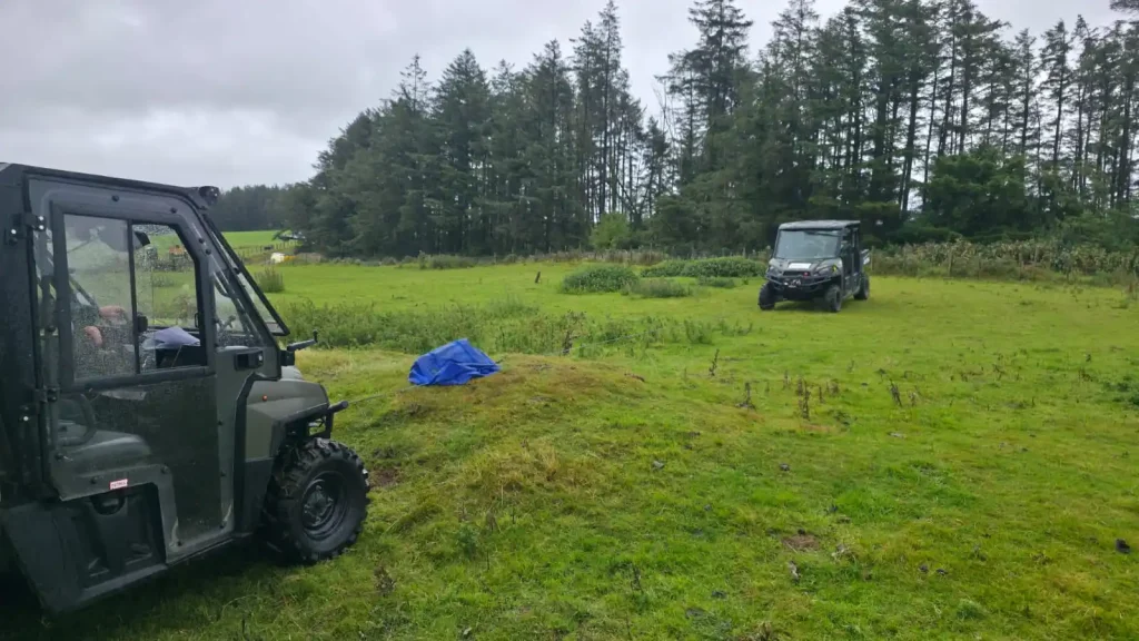 Two Polaris UTVs on grassy hillside during Beyond Driving off-road course in Wales