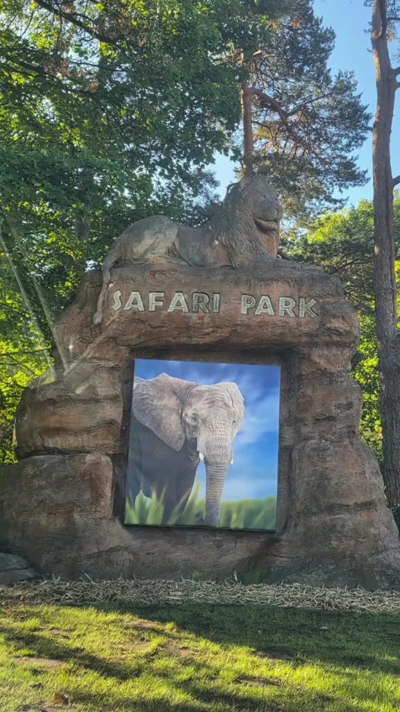 Safari Park entrance sign featuring a lion sculpture and an elephant image