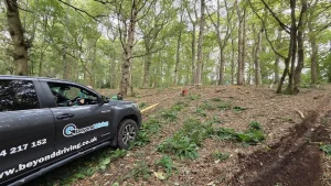Beyond Driving 4x4 vehicle using winch for off-road recovery training in forest with tree anchor