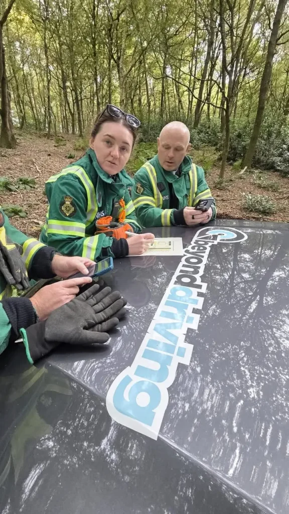 London Ambulance Service NHS HART team reviewing winch training notes on Beyond Driving vehicle bonnet
