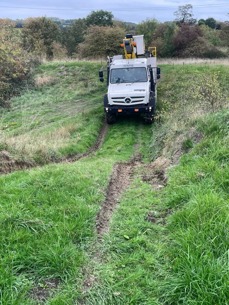 Unimog climbing grassy terrain at Northern Powergrid’s Swillington training ground.