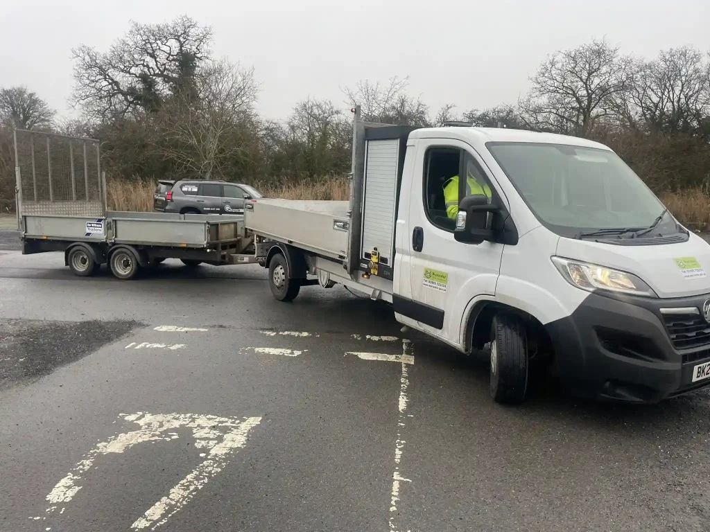 Council flatbed vehicle towing twin-axle trailer during Lantra trailer handling training at depot site