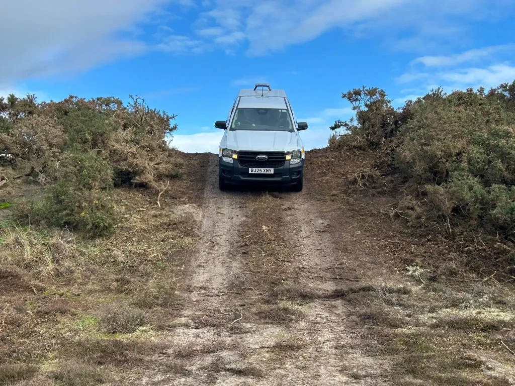 Balfour Beatty vehicle descending a steep off-road track during Lantra 4x4 operator training in northern Scotland