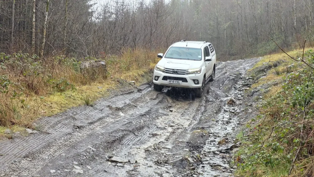 Lantra 4x4 familiarisation course – Toyota Hilux driving through deep rutted woodland track in South Wales