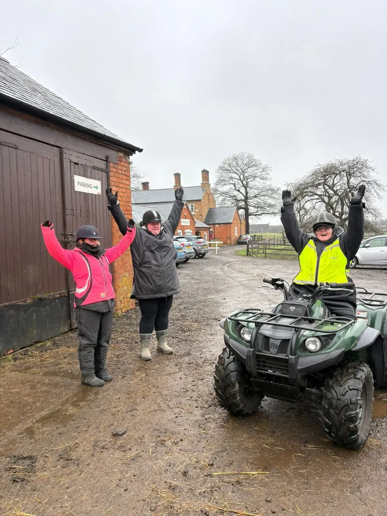 Equestrian centre staff completing Lantra ATV operator training beside quad bike in stable yard
