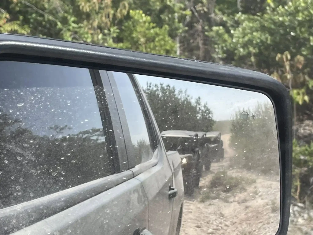 Convoy of off-road vehicles driving through sandy terrain in Turks and Caicos