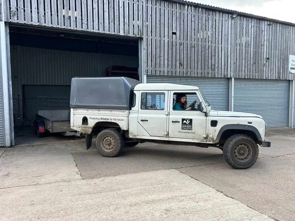 Land Rover Defender towing trailer reversing into barn during driver training