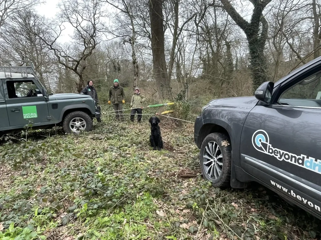 4x4 vehicle recovery using winch line between two vehicles in woodland environment