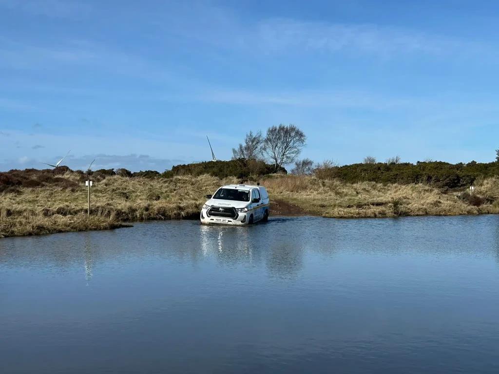 Lantra 4x4 training vehicle entering water crossing in Scotland off road course
