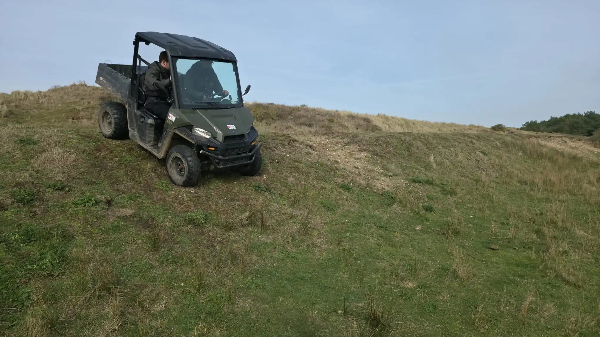 UTV driver descending grassy slope during Lantra training in Norfolk