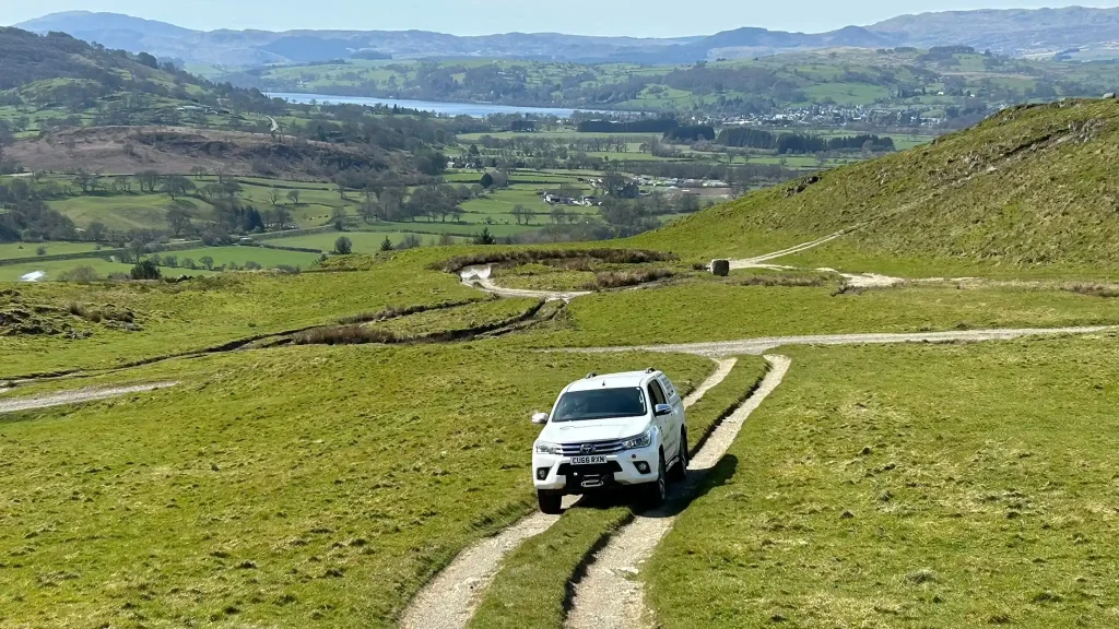 Beyond Driving vehicle navigating rural tracks with valley views in North Wales