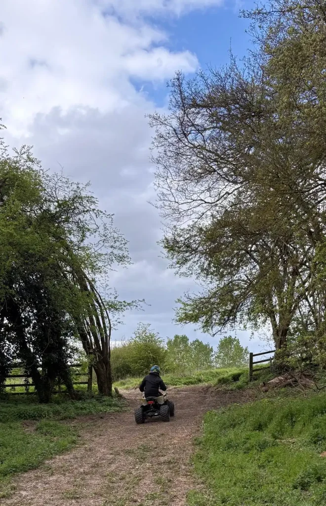     Lantra ATV training candidate riding a quad bike along a woodland track