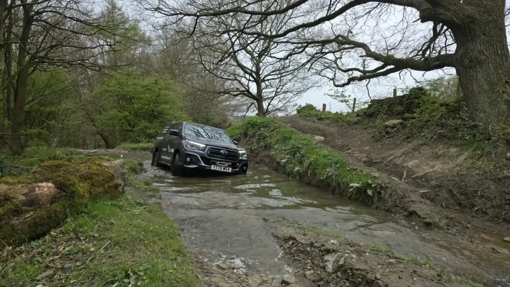 4x4 vehicle navigating muddy woodland track during driver training in Yorkshire