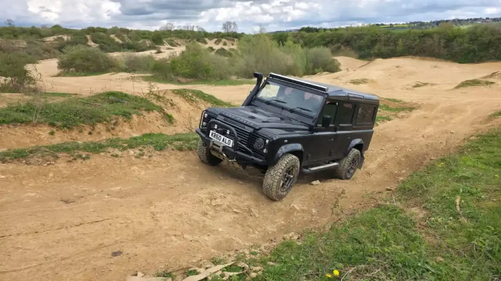 Land Rover Defender climbing off-road incline during 4x4 training Peterborough