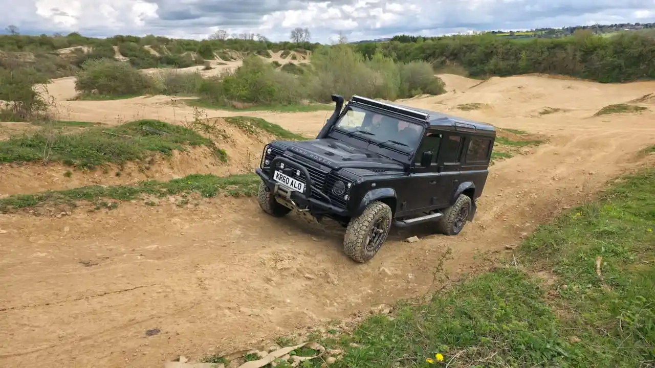 Land Rover Defender climbing off-road incline during 4x4 training Peterborough