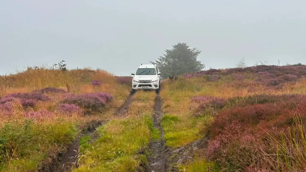 Toyota Hilux negotiating muddy rutted tracks during Lantra 4x4 operator training near Glenrothes, Scotland