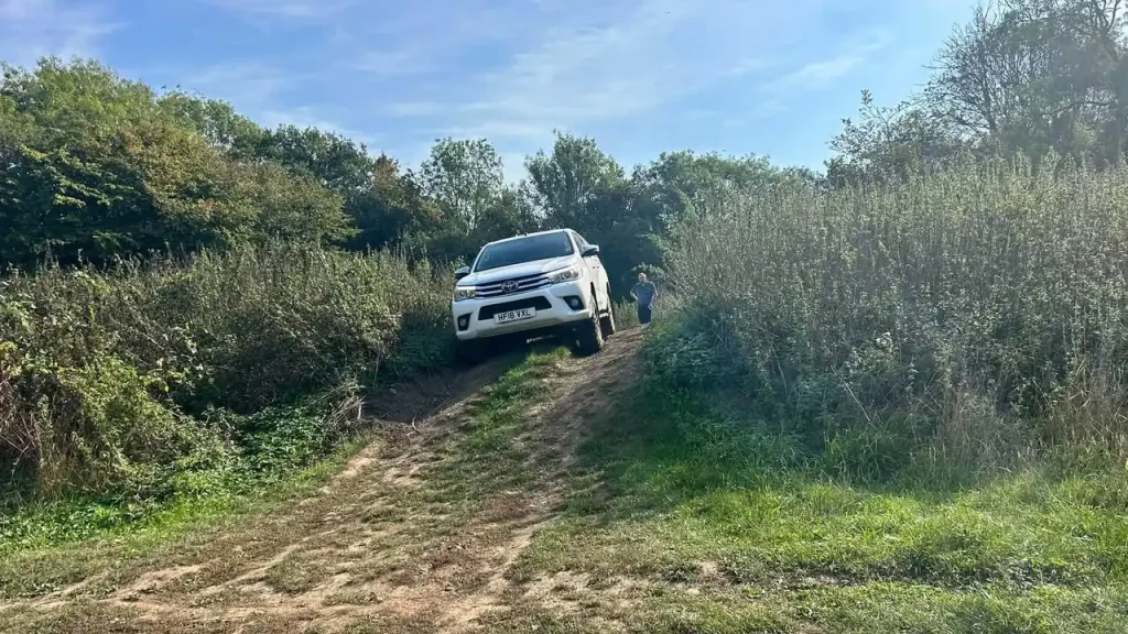 Toyota Hilux negotiating a cross-slope during Lantra 4x4 operator training in Kent